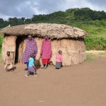 Maasai family in front of their house